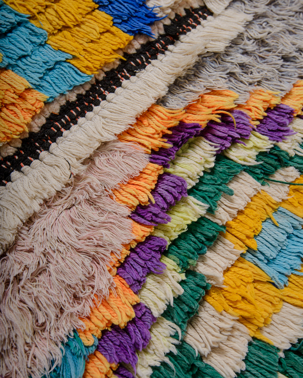 Close up texture of Berberlin vintage Boucherouite runner rug made of colourful cotton, wool and cloth.